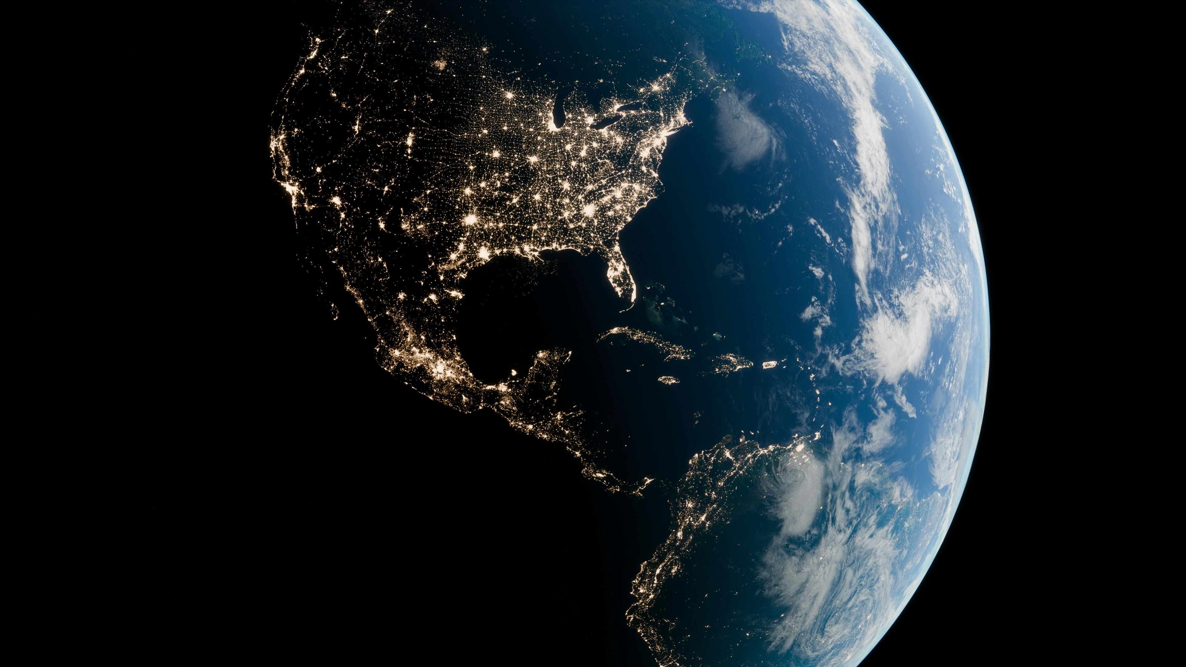 Earth at night from space showing North America illuminated by city lights.