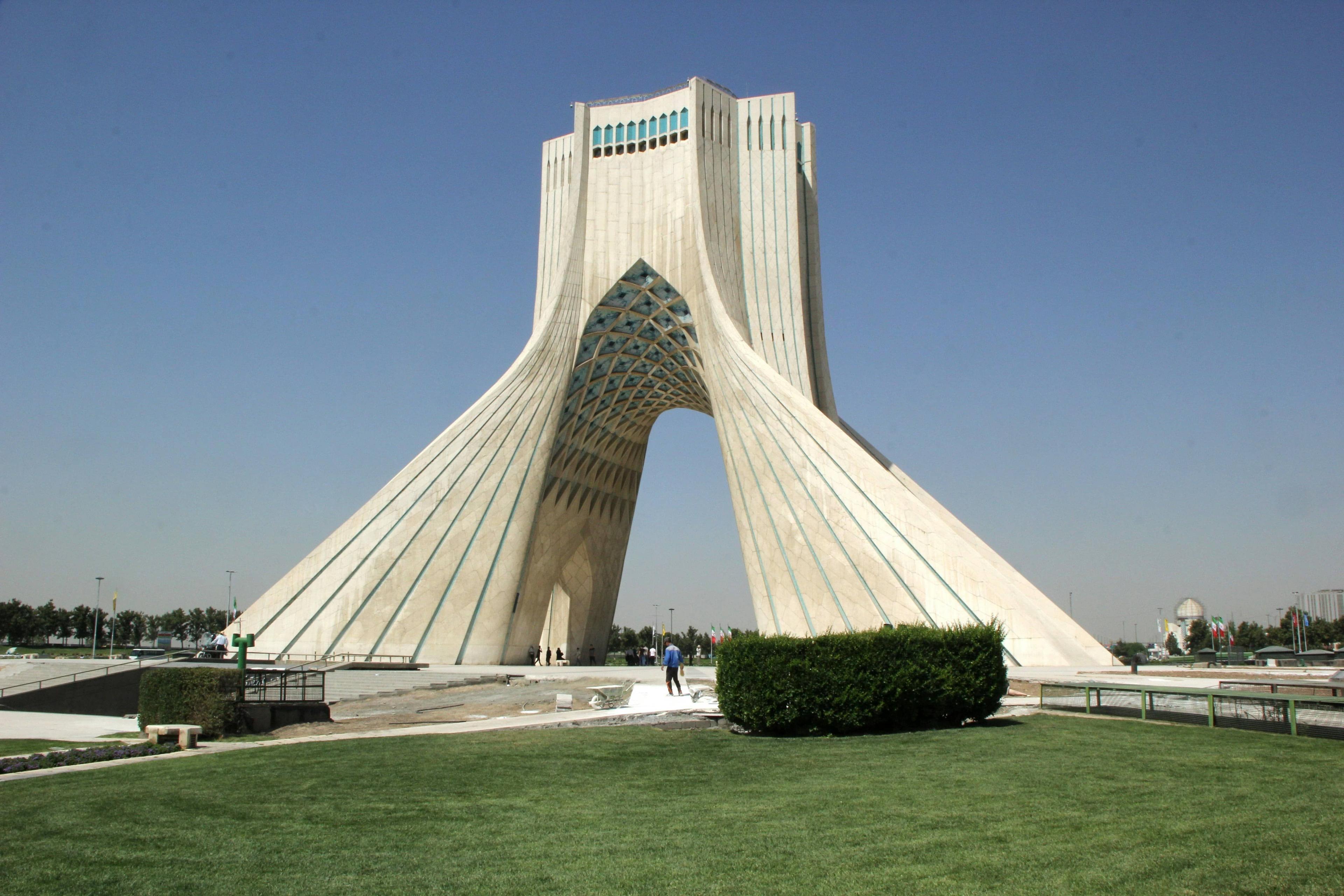 The iconic Azadi Tower in Tehran, Iran, a white marble monument with an arched structure.
