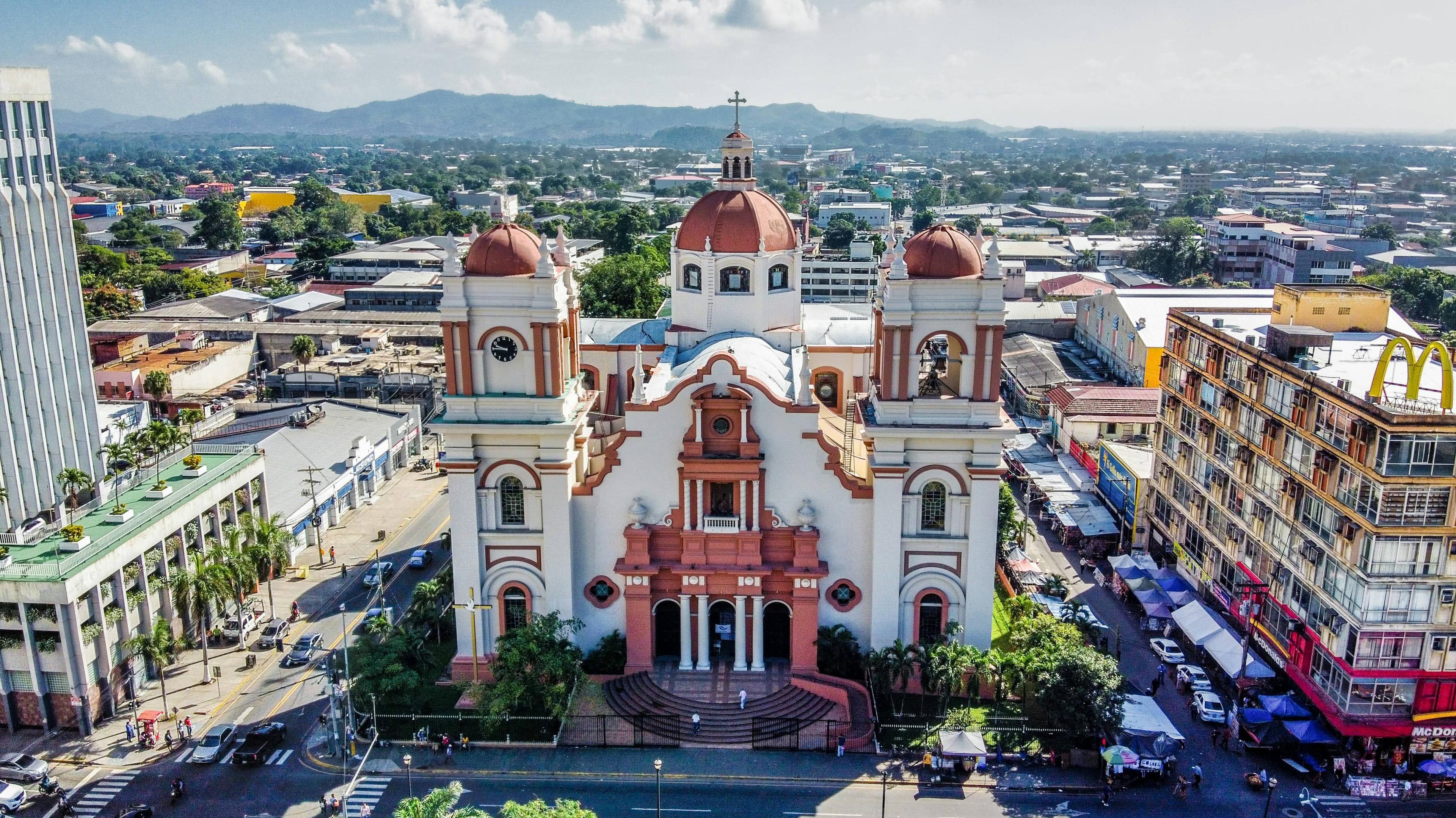 Ornate white and pink church with red domes in Honduras