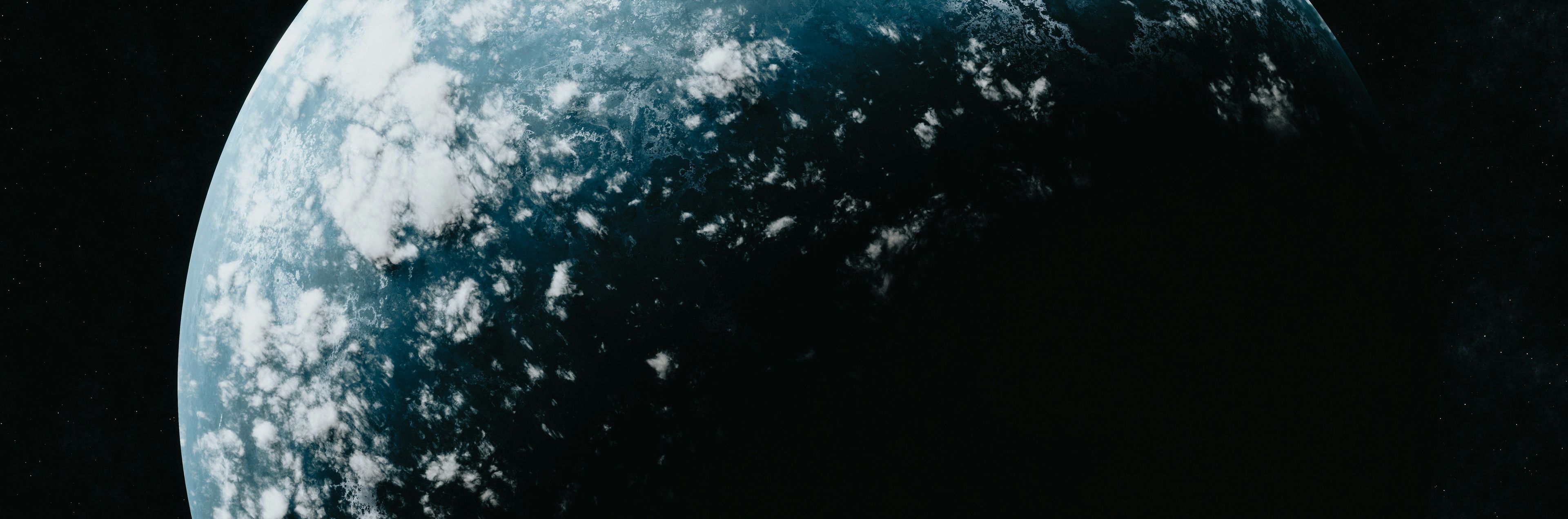 Partial view of a planet from space, showing blue surface and white clouds.
